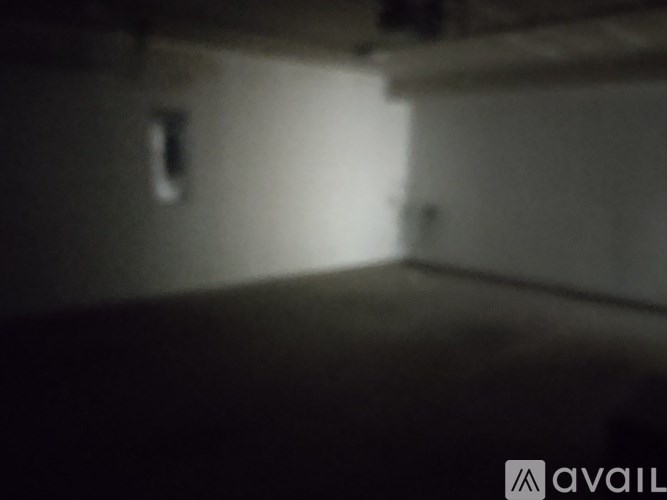 A dark room with a single light source on the wall.