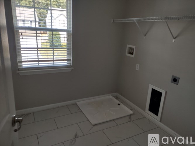 A bathroom with a tub and a window with blinds.