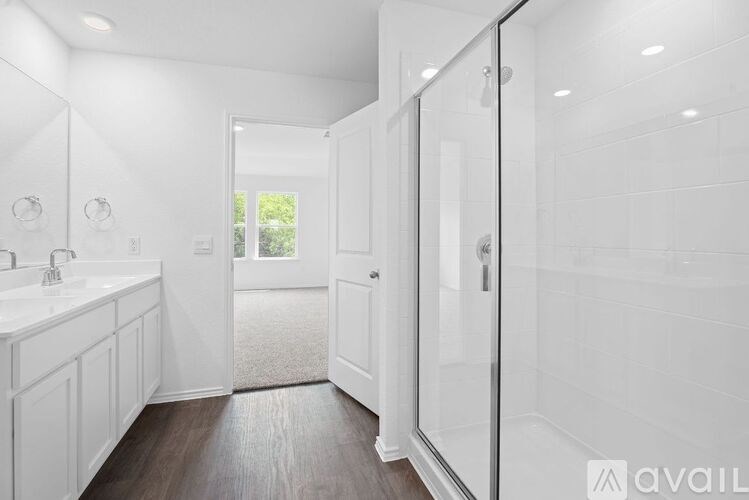 A bathroom with a walk-in shower and a double sink vanity.