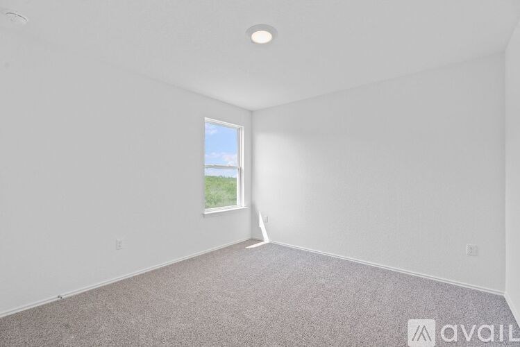 A room with a window and carpeted floor.