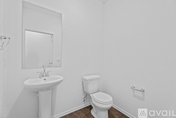 A white bathroom with a sink, toilet and mirror.