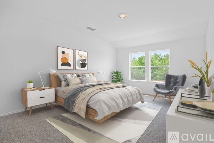 A bedroom with a large bed, a chair, and a potted plant.