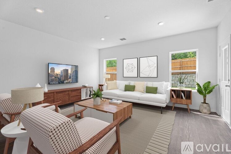A living room with a sofa, a chair, a coffee table, and a TV.