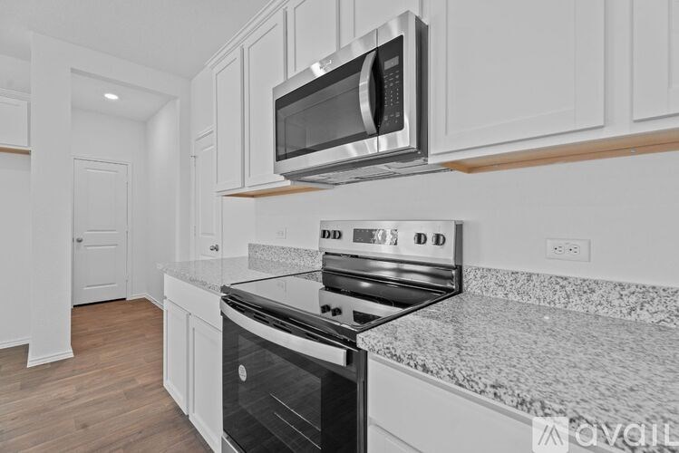 A modern kitchen with a stainless steel oven and microwave above it.