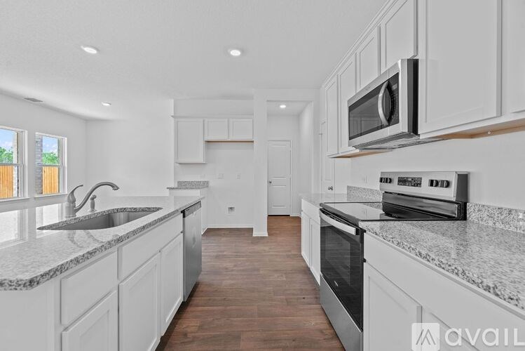 A modern kitchen with white cabinets and a granite countertop.