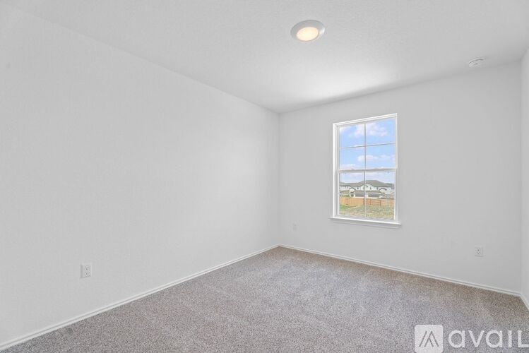 A room with a window and a picture on the wall.