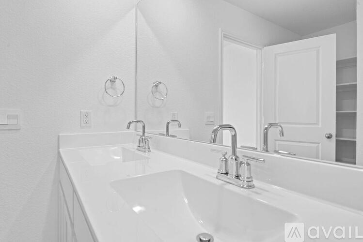 A white bathroom with a large sink and mirror.