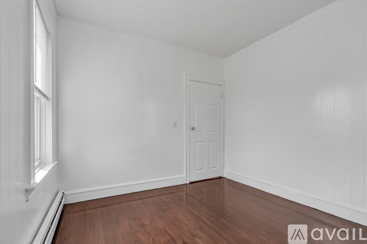 A room with a wooden floor and white walls.