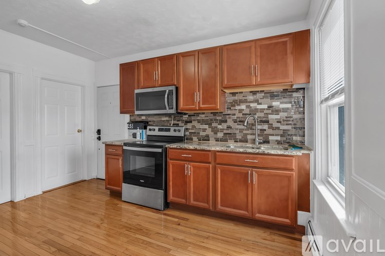 A kitchen with wooden cabinets and a stone backsplash.