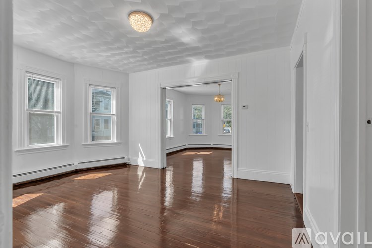 A spacious room with wooden floors and white walls.