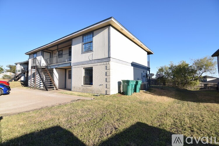 A two-story house with a garage and a car parked in front.