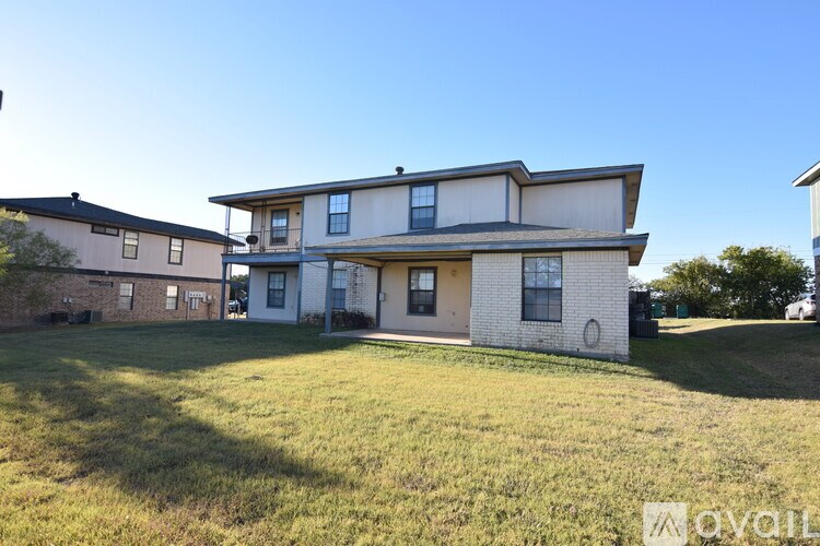 A two-story house with a large front yard is available for rent.