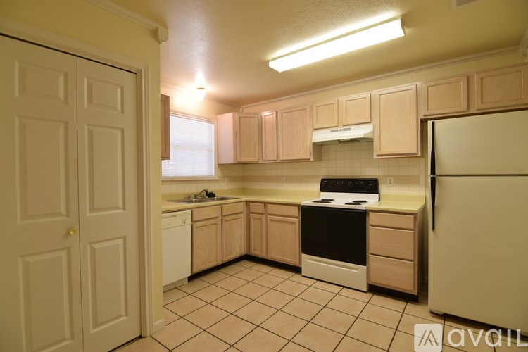 A kitchen with a white fridge, white dishwasher, and black stove.