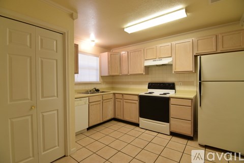 A kitchen with a white fridge, white dishwasher, and black stove.