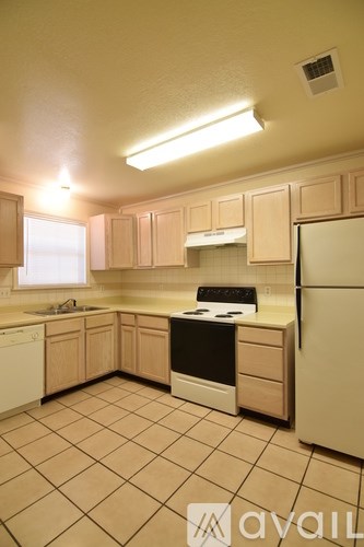 A kitchen with white appliances and cabinets.