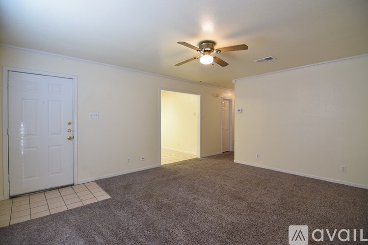 A room with a ceiling fan and carpeted floor.