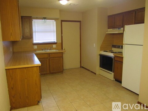 A kitchen with wooden cabinets and a white refrigerator.
