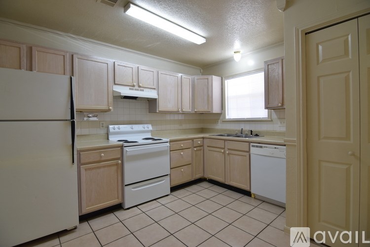 A kitchen with white appliances and wooden cabinets.