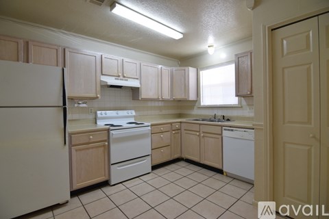 A kitchen with white appliances and wooden cabinets.