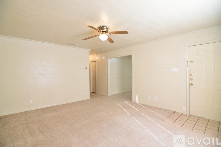 A room with a ceiling fan and carpeted floor.