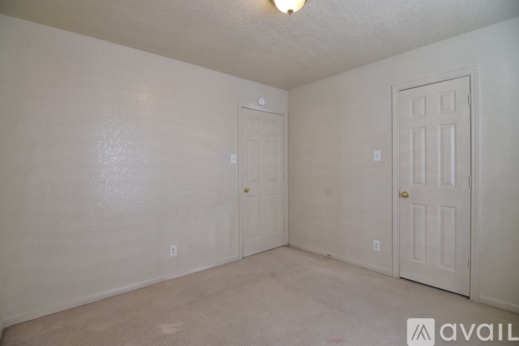 A room with two doors and a carpeted floor.
