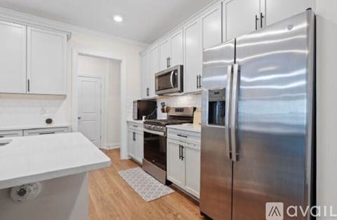 A modern kitchen with stainless steel appliances and white cabinetry.