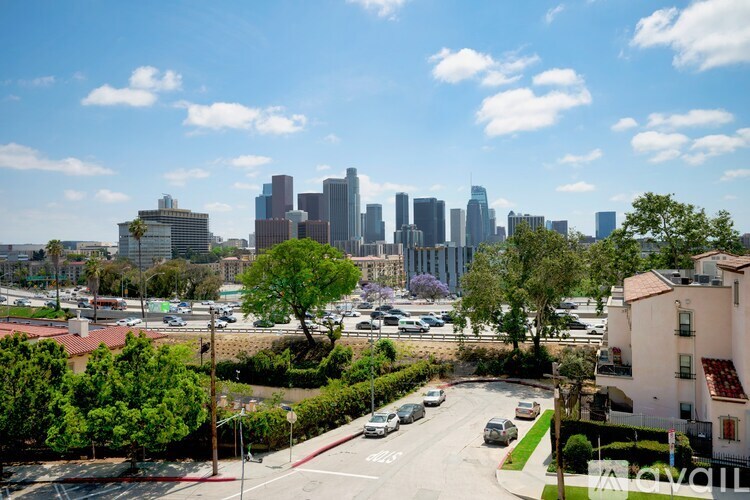 A cityscape with a clear blue sky and buildings in the distance.
