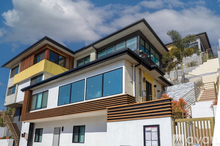 A modern multi-story house with a white base and yellow and brown accents.