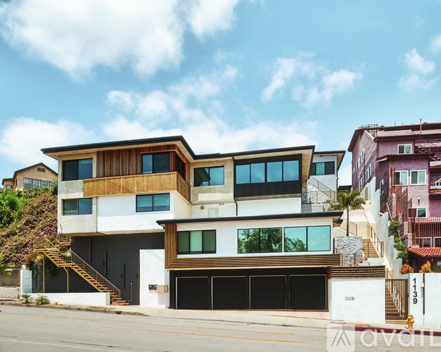 A modern two-story house with a balcony on the second floor.