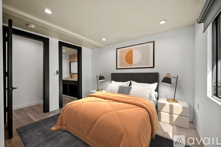 A bedroom with a bed covered in an orange comforter.