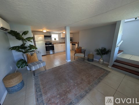 A living room with a striped chair and a rug.