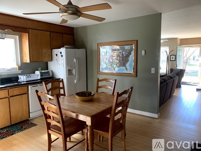 A kitchen with a table and chairs and a refrigerator.