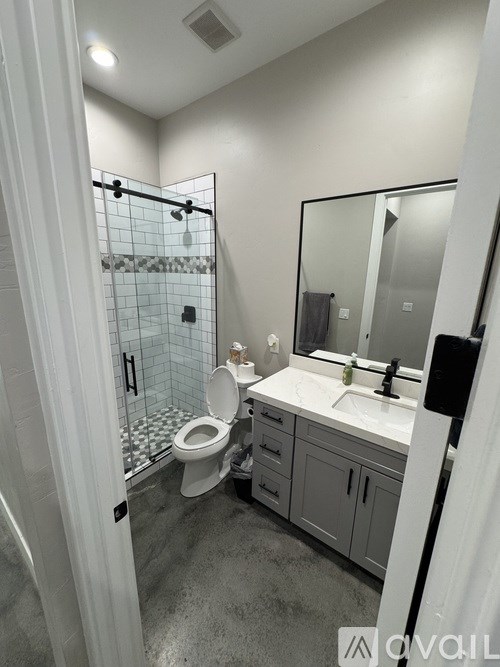 A bathroom with a toilet, sink, and shower.