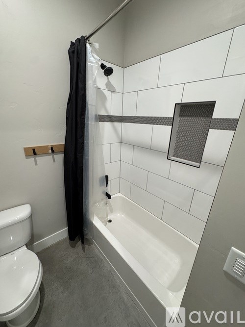 A bathroom with a toilet, a bathtub, and a shower curtain.
