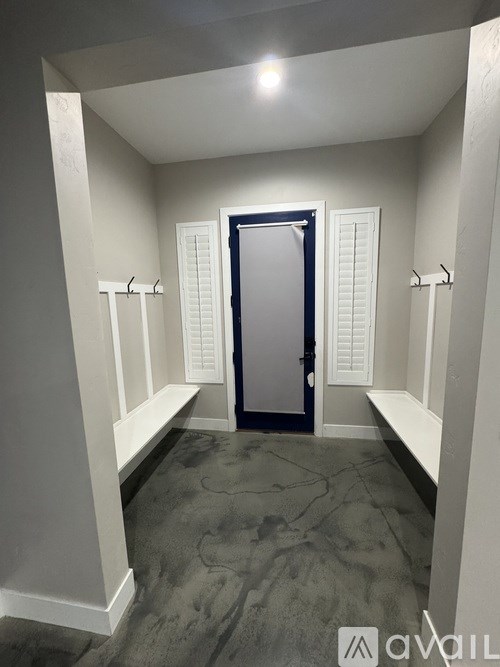 A hallway with a black door and white walls.