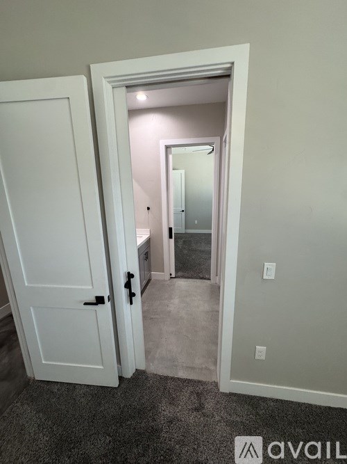 A white door is open to a small bathroom.
