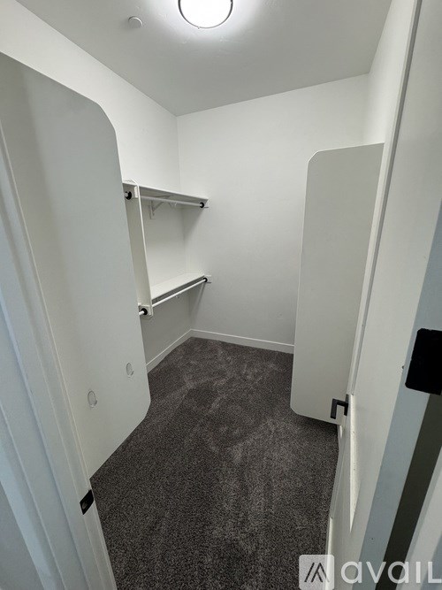 A small, empty room with a carpeted floor and white walls.