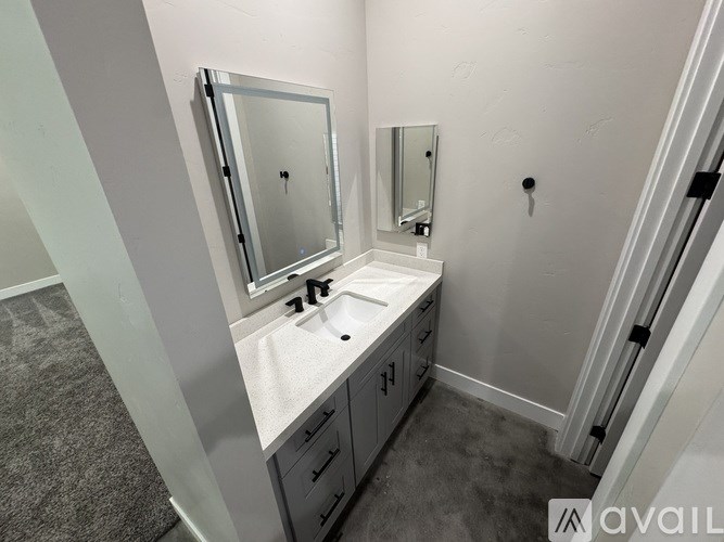 A bathroom with a sink, mirror, and a towel rack.