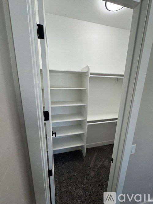 A white shelving unit is in a white doorway.