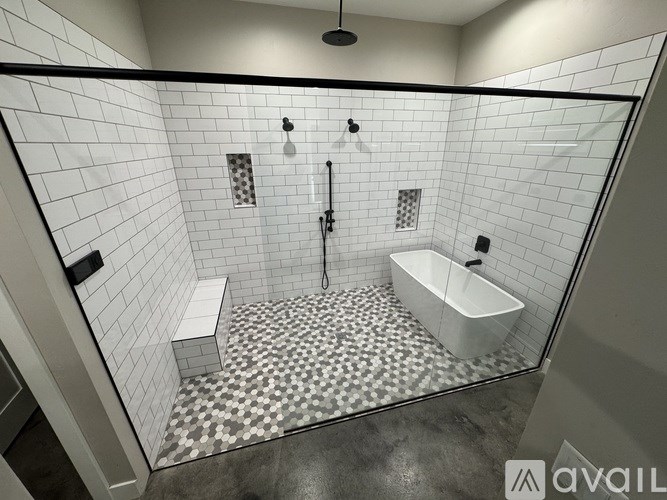 A bathroom with a black and white tiled floor and walls.