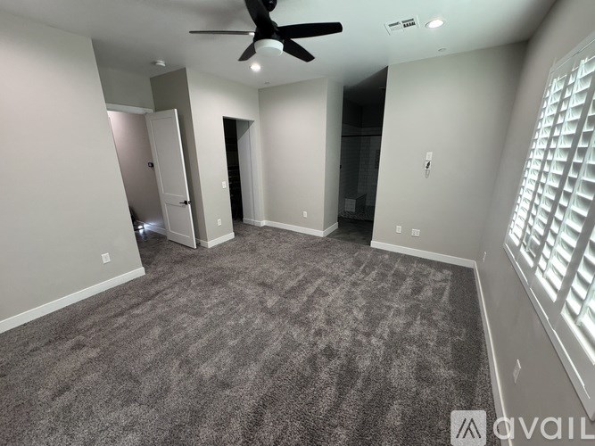 A room with a ceiling fan and carpeted floor.
