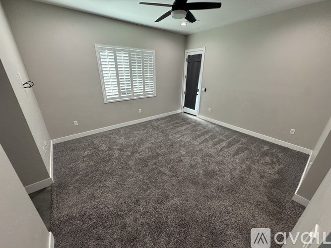 A room with a ceiling fan and a door.