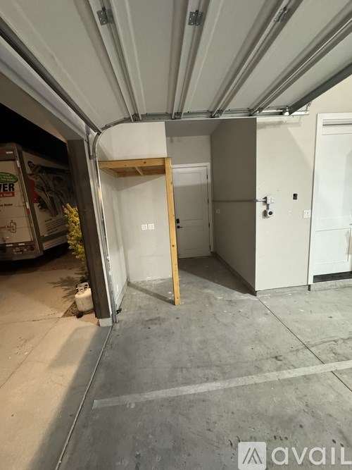 A room with a doorway frame missing its door and a wall of boxes in the background.