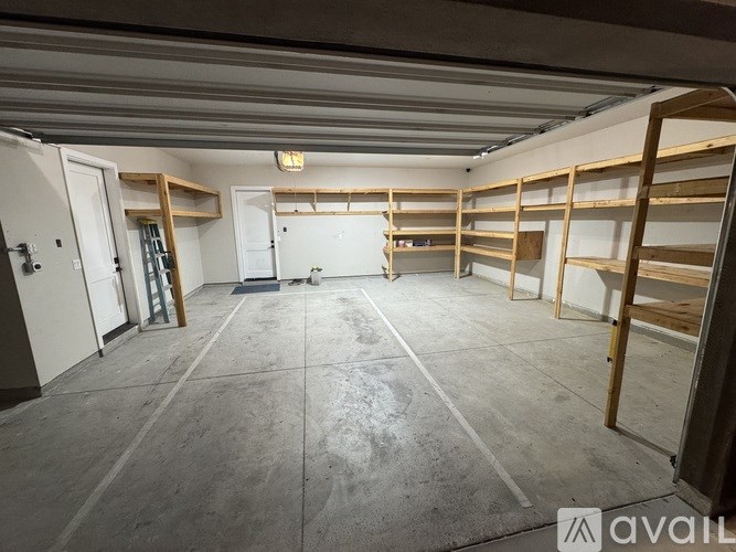 A spacious garage with wooden shelving units and a concrete floor.