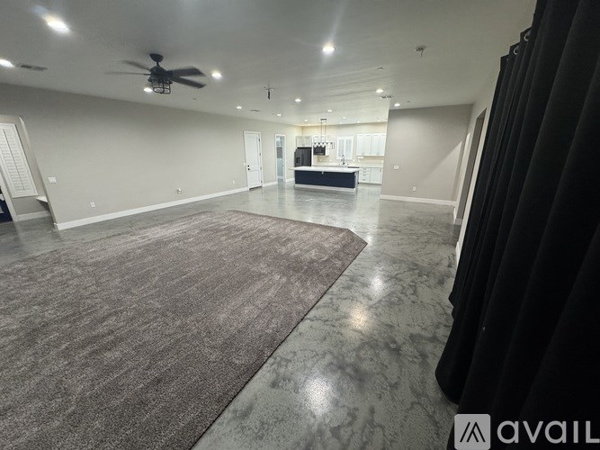 A spacious room with a marble floor and a ceiling fan.