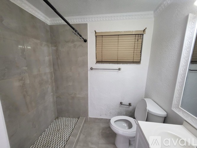 A bathroom with a toilet, sink, and shower.