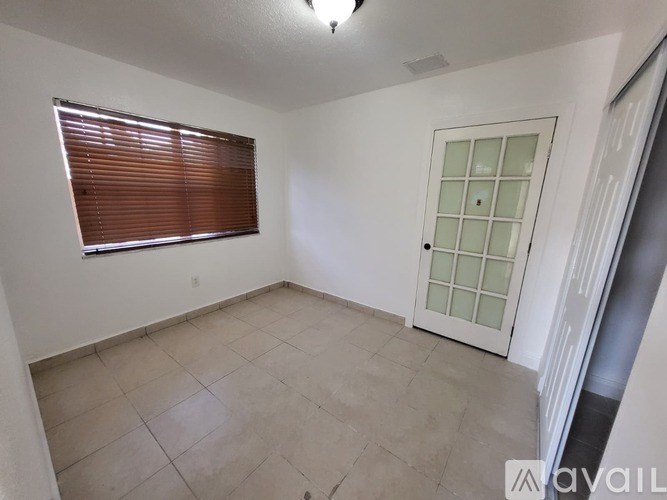 A room with a door, window, and tiled floor.
