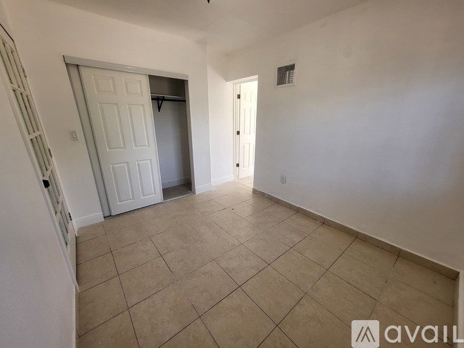 A room with a white door and a white wall.