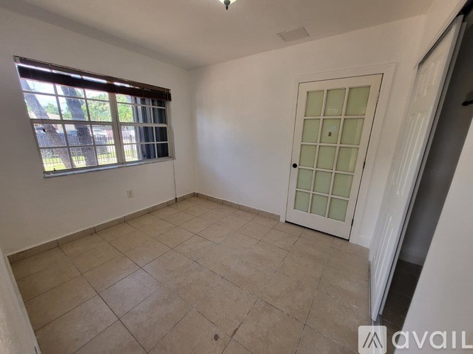 A room with a window and a door is available for rent.