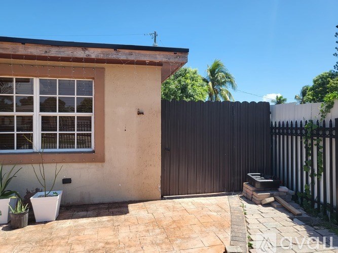 A house with a brown door and a black fence.